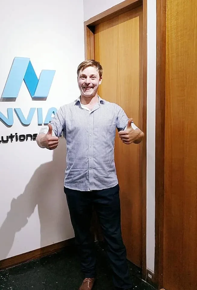 An Anviam team member celebrating in front of the office signage